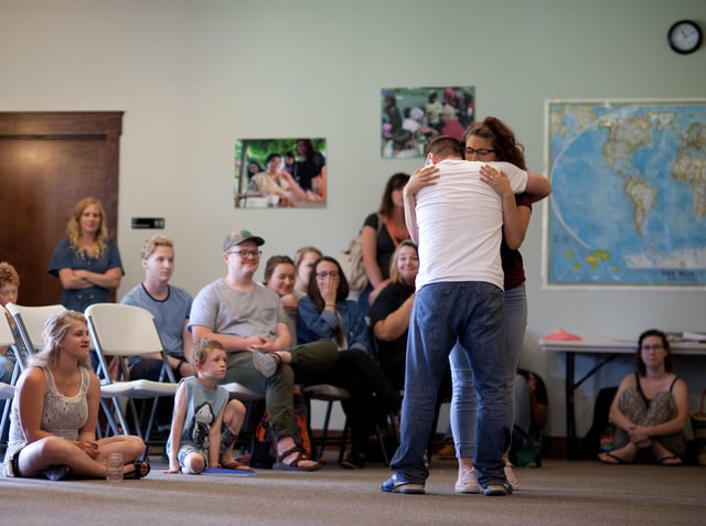A DTS student emotionally hugging a school speaker